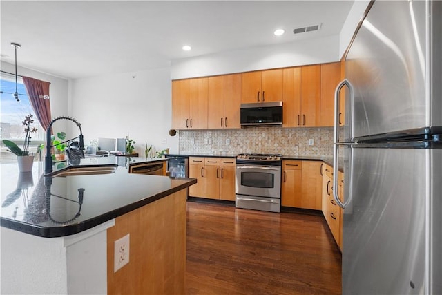 kitchen with visible vents, backsplash, dark wood finished floors, appliances with stainless steel finishes, and a sink