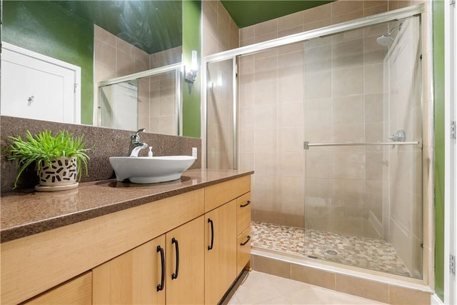 full bathroom featuring vanity, tile patterned floors, a stall shower, and backsplash