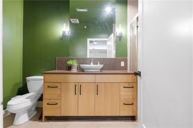 bathroom with tile patterned floors, visible vents, toilet, a shower with door, and vanity