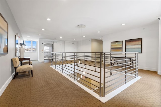 hall with carpet, recessed lighting, an upstairs landing, and baseboards