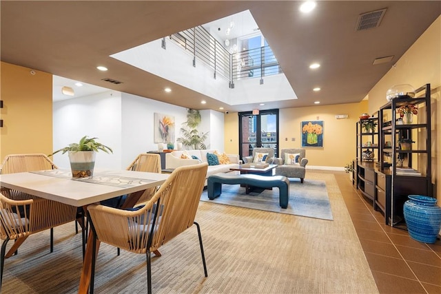 tiled dining room with recessed lighting, visible vents, and a towering ceiling