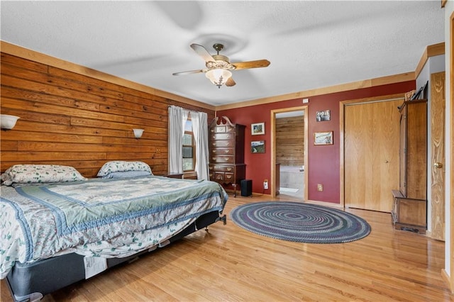 bedroom with ceiling fan, wood finished floors, baseboards, and a textured ceiling