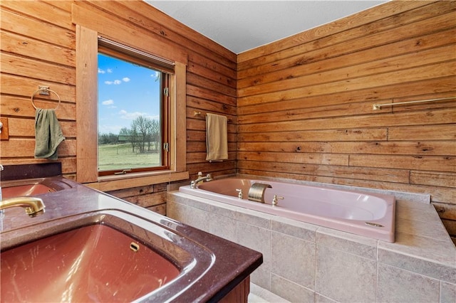 bathroom with a sink and tiled bath