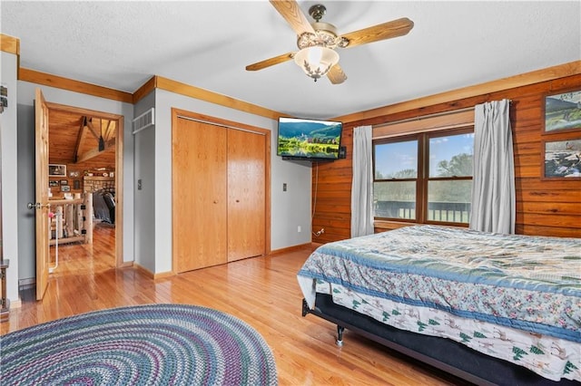 bedroom featuring visible vents, baseboards, wood finished floors, a textured ceiling, and a ceiling fan