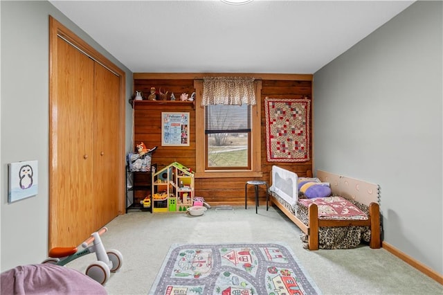 carpeted bedroom featuring a closet and baseboards