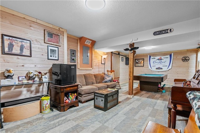 living area with visible vents, electric panel, a textured ceiling, wooden walls, and pool table