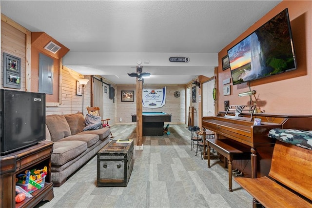 living area with pool table, electric panel, visible vents, and wood walls