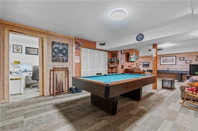 game room featuring wooden walls, pool table, and a textured ceiling