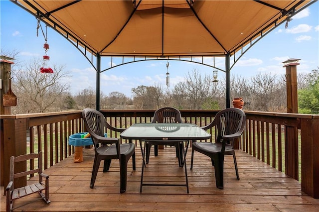 wooden deck featuring a gazebo and outdoor dining space