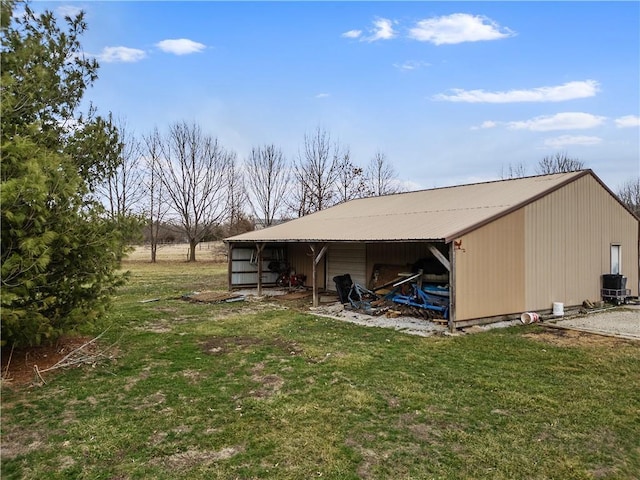 exterior space with an outbuilding, a lawn, a pole building, metal roof, and central AC unit