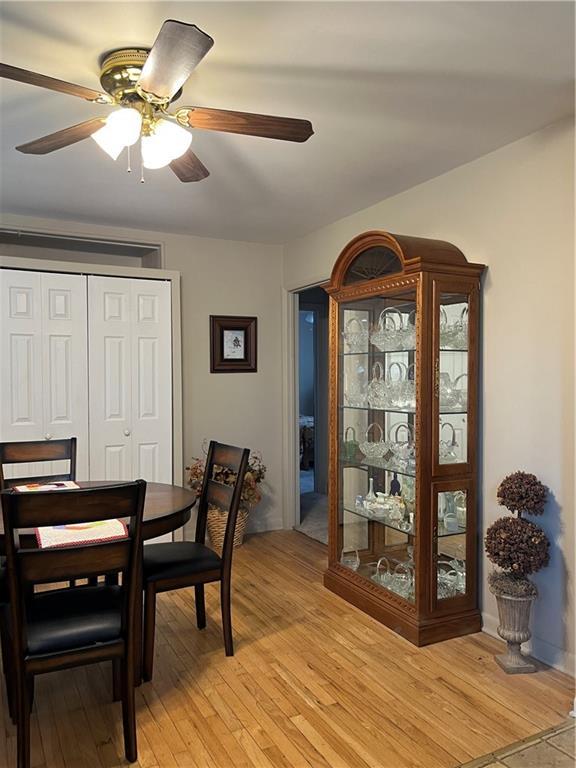 dining area with light wood-style flooring and ceiling fan