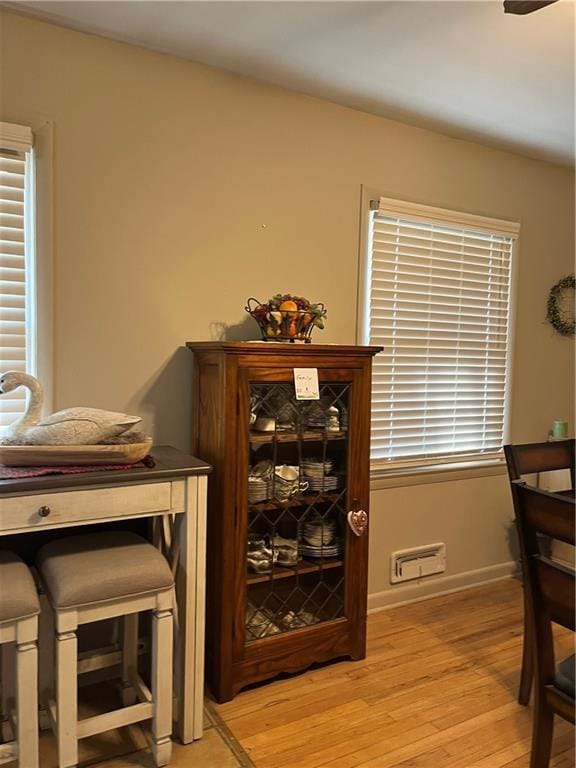 dining space with baseboards and light wood-type flooring