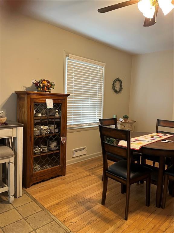 dining space with baseboards, light wood-type flooring, and ceiling fan