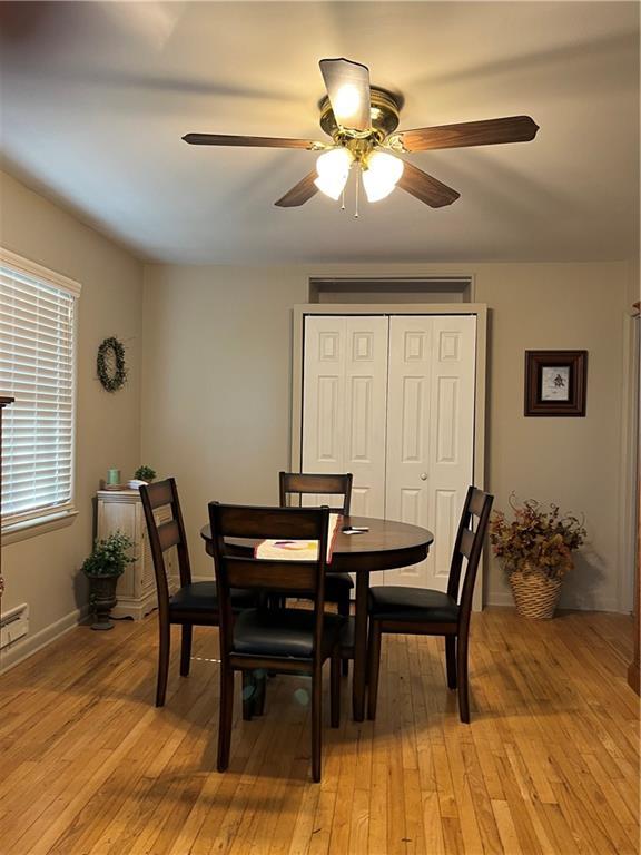 dining space with light wood-style flooring and a ceiling fan