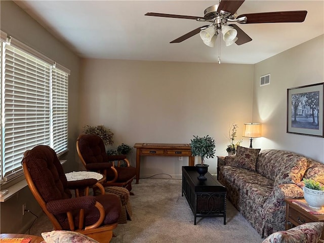 carpeted living room featuring visible vents and a ceiling fan