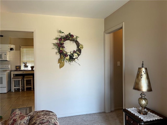 hall with tile patterned flooring, baseboards, and carpet floors