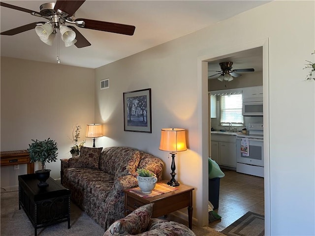 living room with visible vents and a ceiling fan