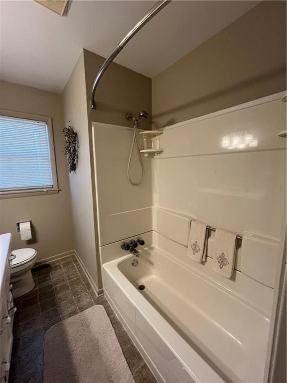 bathroom featuring vanity, toilet, shower / tub combination, and baseboards