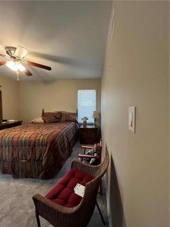 carpeted bedroom featuring visible vents and ceiling fan