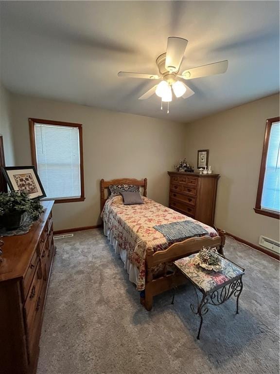 bedroom with a baseboard heating unit, a ceiling fan, baseboards, and carpet floors