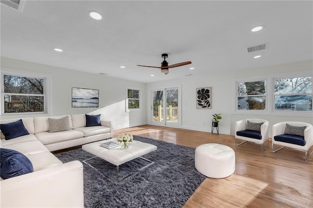 living area with recessed lighting, visible vents, wood finished floors, and a ceiling fan