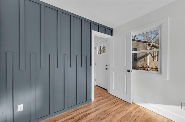 interior space with light wood-style flooring and a decorative wall