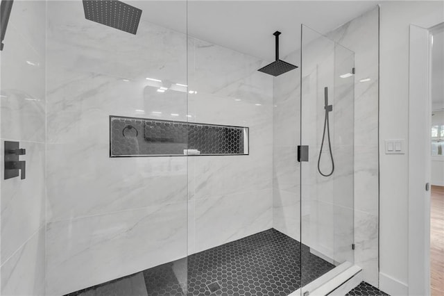 bathroom featuring a marble finish shower