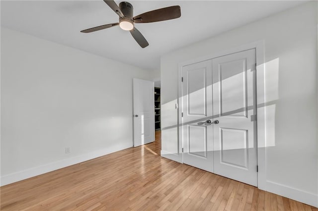 unfurnished bedroom with light wood-type flooring, baseboards, and a ceiling fan