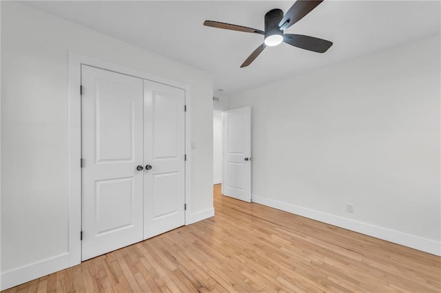 unfurnished bedroom with a closet, baseboards, ceiling fan, and light wood finished floors