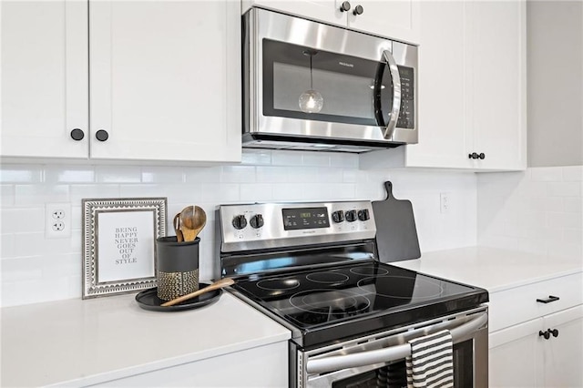 kitchen with backsplash, white cabinetry, stainless steel appliances, and light countertops