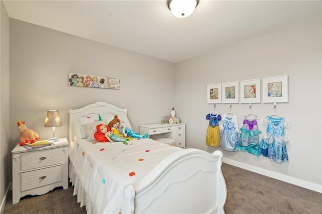 bedroom with dark carpet and baseboards