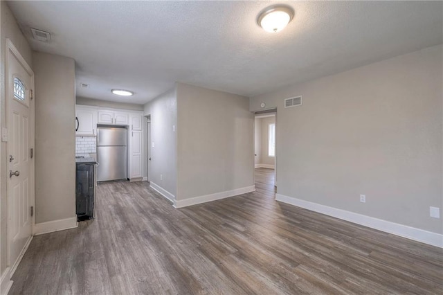 interior space featuring dark wood-style floors, visible vents, and baseboards