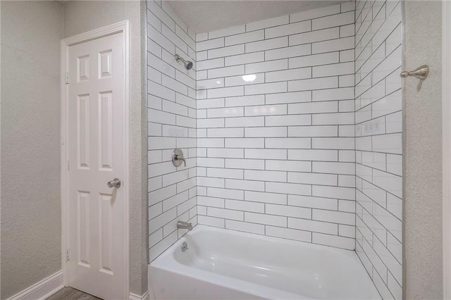 full bathroom featuring bathtub / shower combination and a textured wall