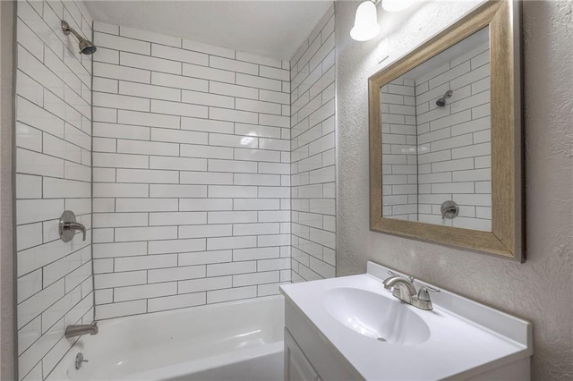 full bath featuring shower / bath combination, vanity, and a textured wall