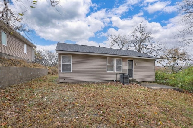 back of property with cooling unit and a lawn