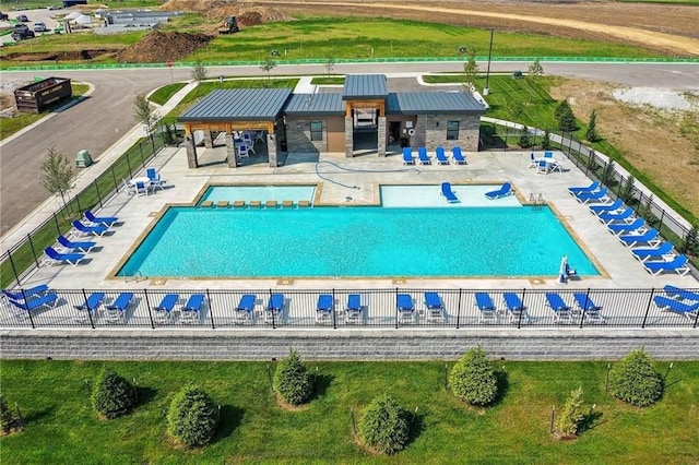 community pool with a patio and fence