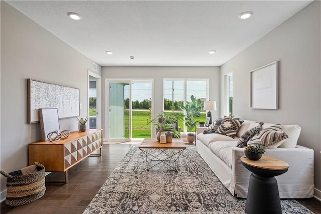 living room featuring visible vents, recessed lighting, a textured ceiling, and dark wood-type flooring