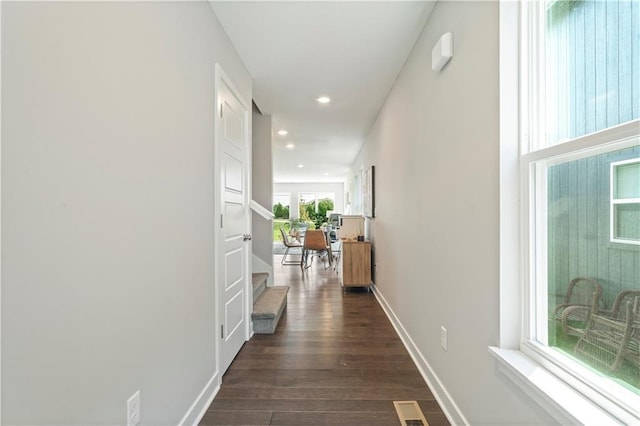 corridor with dark wood-type flooring, recessed lighting, baseboards, and visible vents