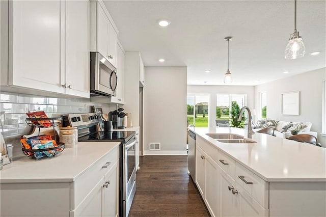 kitchen featuring decorative backsplash, light countertops, appliances with stainless steel finishes, and a sink