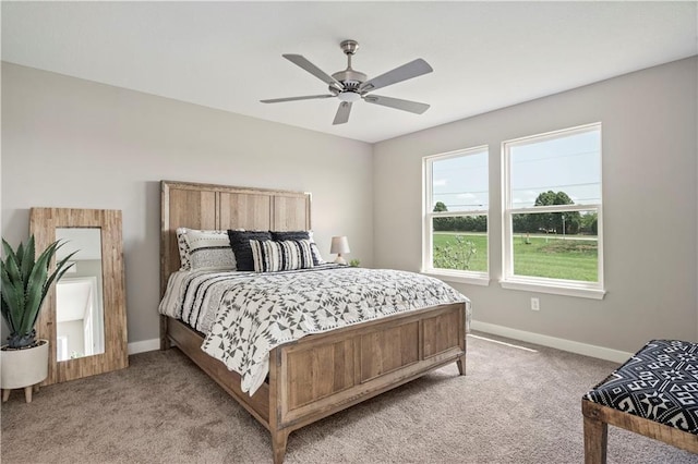 bedroom with baseboards, light colored carpet, and a ceiling fan