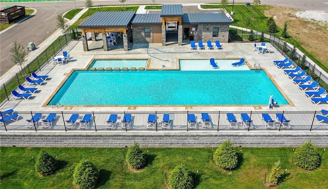 community pool with a patio and fence