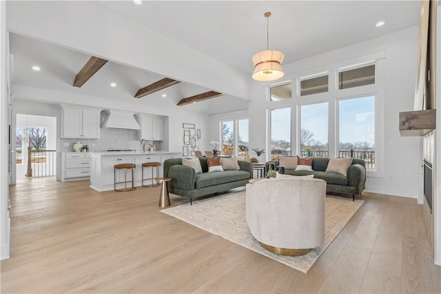 living area with light wood-style flooring, recessed lighting, beamed ceiling, and baseboards