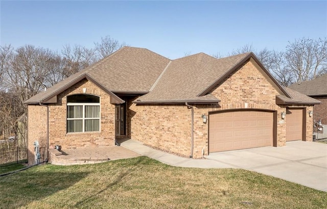 view of front of property with fence, driveway, an attached garage, a front lawn, and brick siding