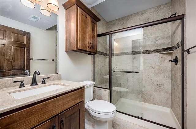 bathroom featuring visible vents, vanity, toilet, and a shower stall