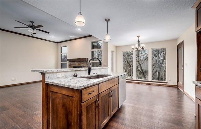 kitchen featuring baseboards, a sink, dark wood-type flooring, pendant lighting, and dishwasher