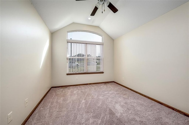 unfurnished room with carpet flooring, ceiling fan, baseboards, and lofted ceiling