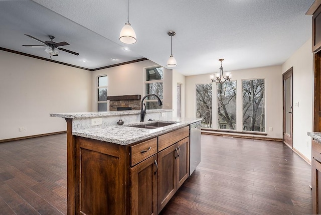 kitchen with baseboards, dark wood finished floors, dishwasher, pendant lighting, and a sink