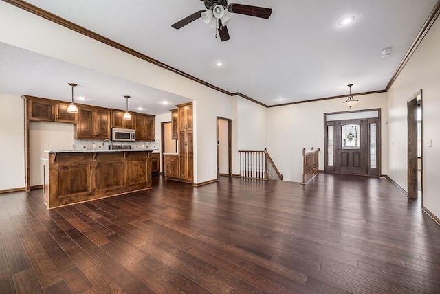 unfurnished living room featuring dark wood-style floors, baseboards, and a ceiling fan