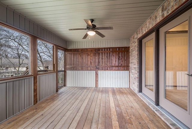 unfurnished sunroom featuring ceiling fan