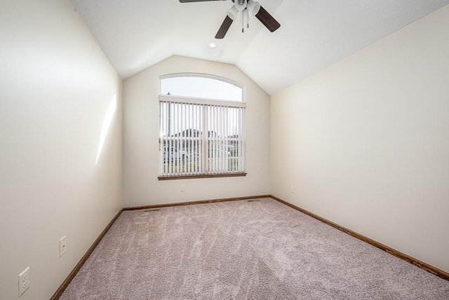 carpeted spare room with baseboards, ceiling fan, and vaulted ceiling